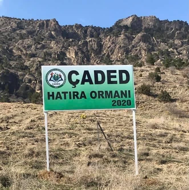 ÇADED Memorial Forest 2020 sign with a rocky hill behind